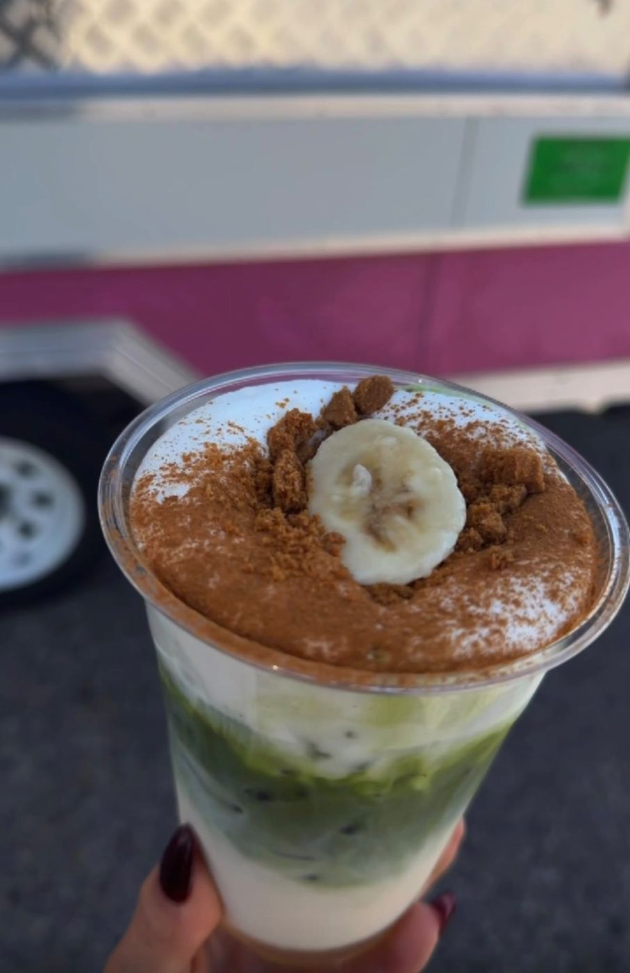 Banana pudding matcha with cookie crumble in front of the pink trailer