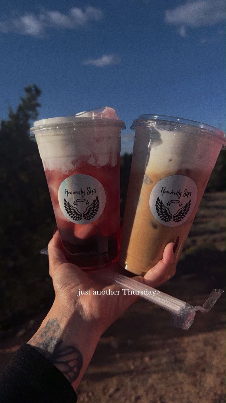 Two layered drinks held up against the sky