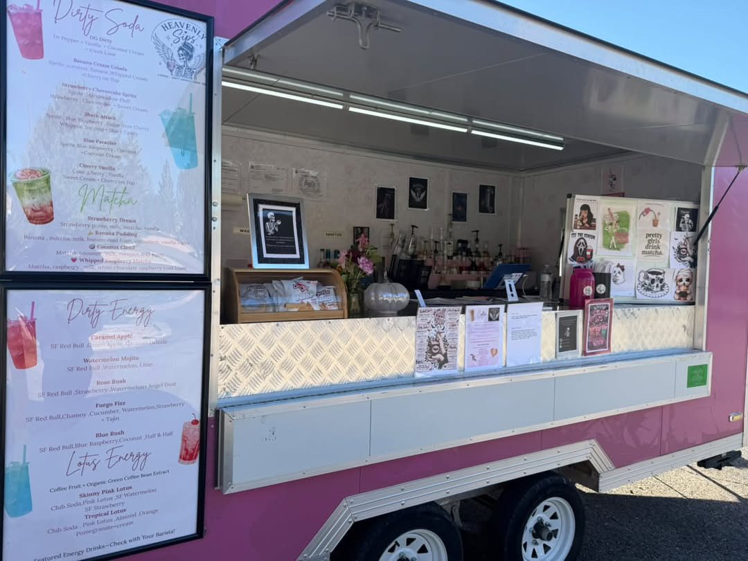 The pink Heavenly Sips trailer with its service window open and menu boards on the side